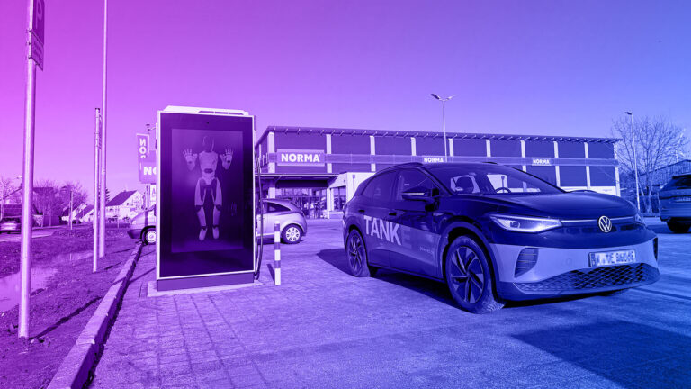 Ladestation und E-Auto auf einem Supermarktparkplatz